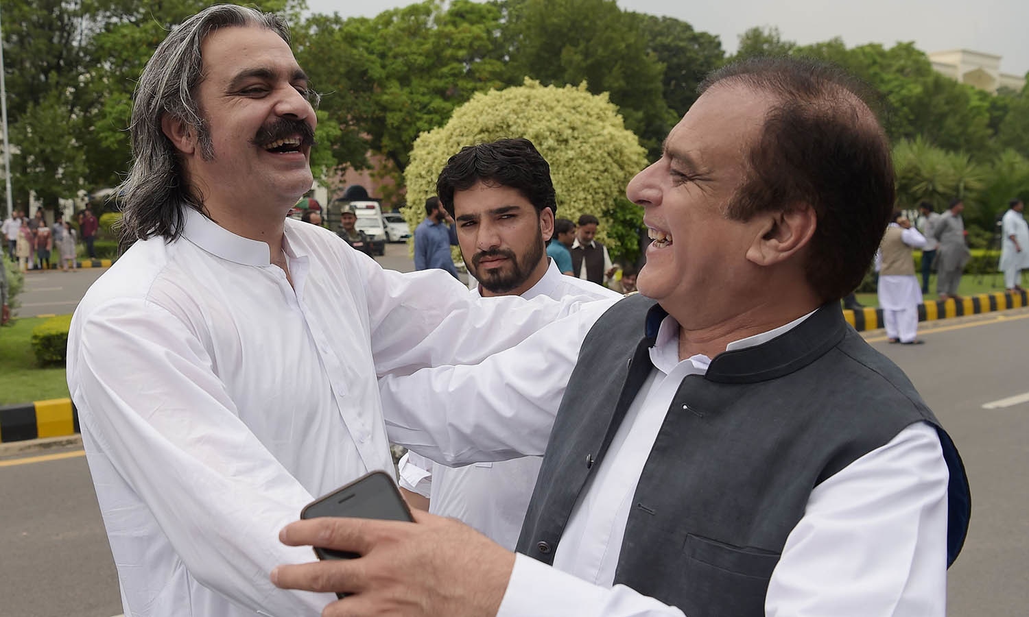 PTI leaders Ali Amin Khan Gandapur and Shibli Faraz celebrate after the SC verdict against Nawaz Sharif. —AFP