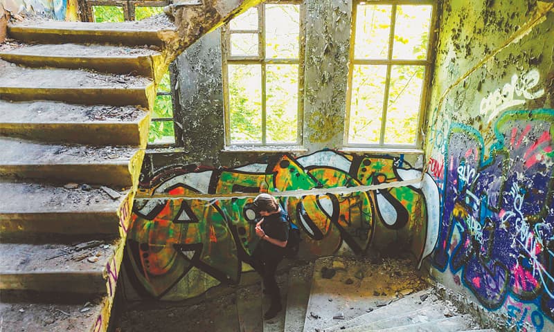 Urban exploration specialist Ciaran Fahey walks through an abandoned building in Berlin.&mdash;AFP