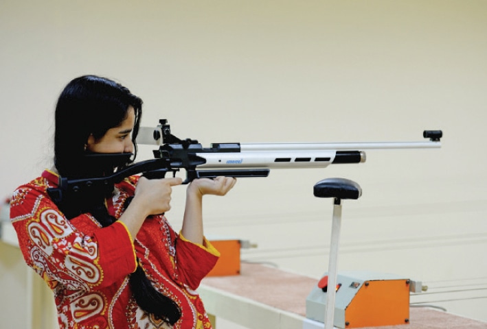 A young woman aims an air rifle at the 10-metre shooting range.