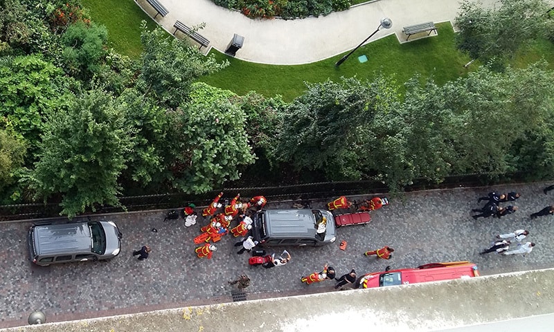 Officials and rescuers gather near vehicles after a car slammed into soldiers in Levallois-Perret, outside Paris.— AFP