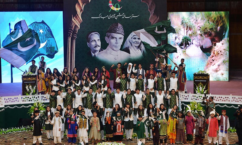 Youths sing a song after a flag hoisting ceremony to mark the country's Independence Day in Islamabad. — AFP