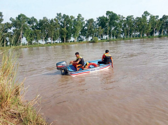 SIALKOT: Divers search for the bodies of a woman and her son in the Upper Chenab Canal. &mdash; Dawn