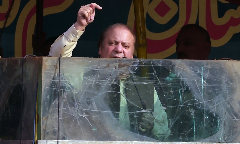 Nawaz Sharif speaks behind a bullet-proof glass during a rally in Gujrat.— AFP/File