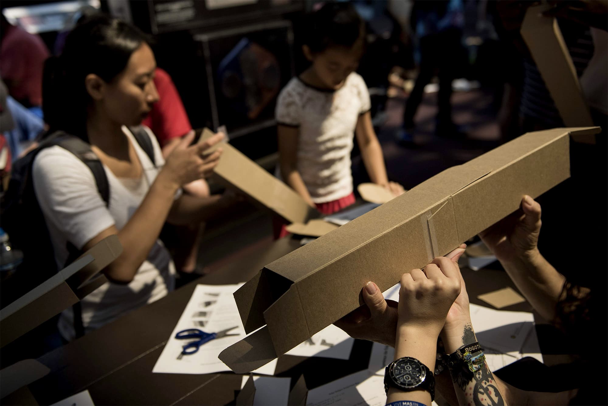 People make pinhole eclipse viewers in the Smithsonian's Air and Space Museum on the National Mall before an eclipse August 21, 2017 in Washington, DC. — AFP