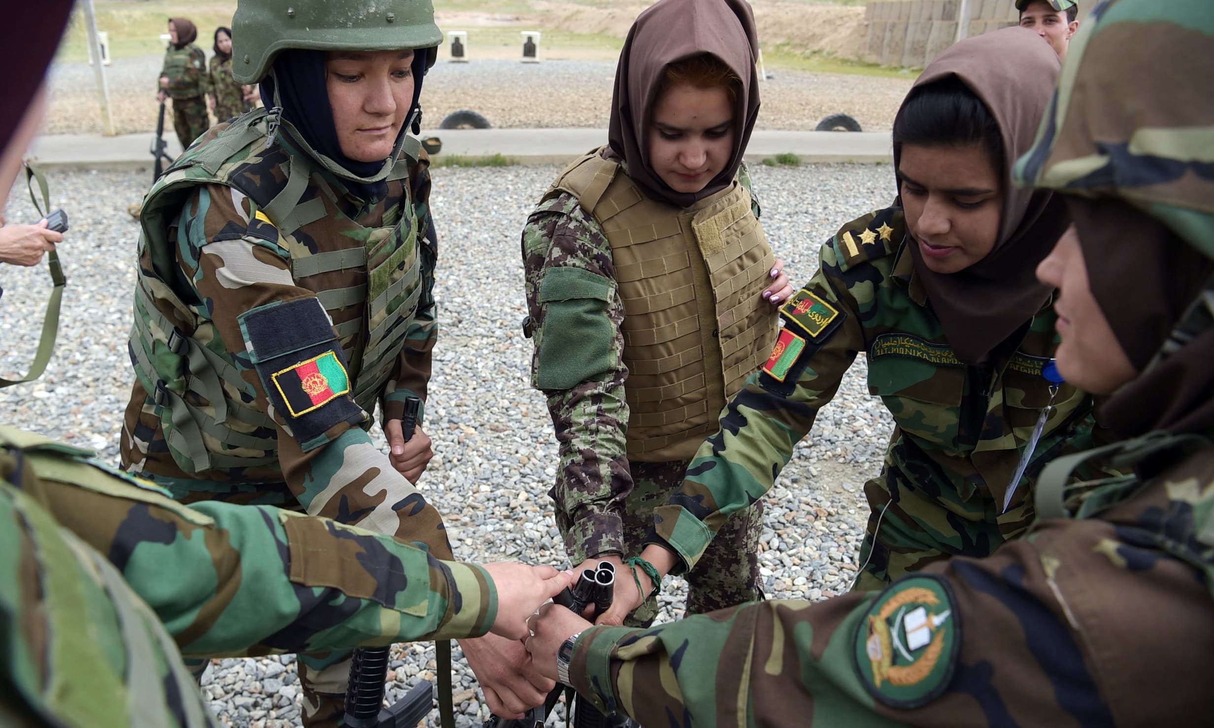 Female soldiers get their rifles at a range during a live firing exercise at the Kabul Military training centre on the outskirts of Kabul. —AFP