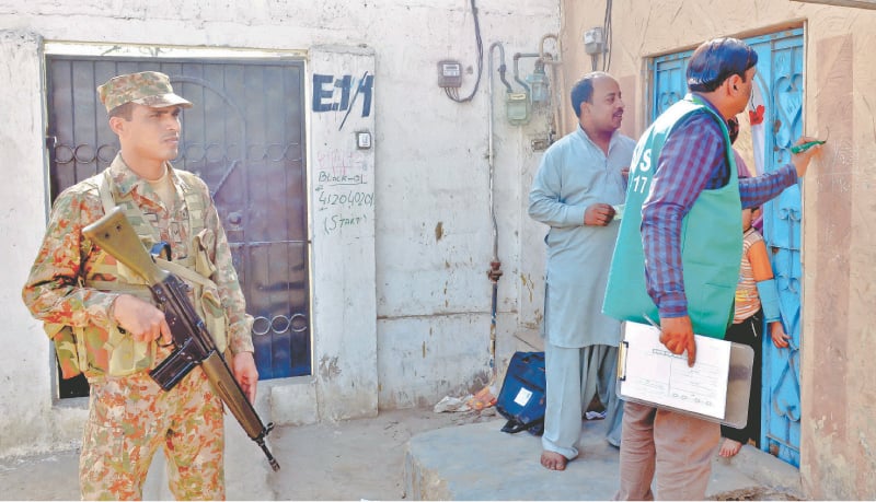 A Rangers' personnel stands guard as census staff carry out their duty