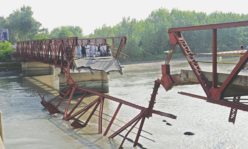 CHARSADDA: People gather after a British-era bridge on the Kabul river gave way on Saturday. A part of the bridge broke and collapsed when a truck carrying over 1,000 cement bags was passing through it.
—Shahbaz Butt / White Star