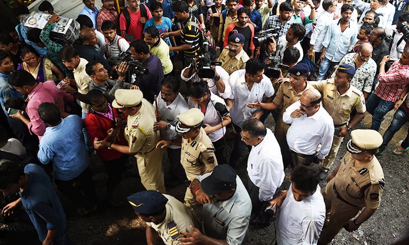 Indian security personnel walk through the scene of a stampede on a railway bridge in Mumbai.─AFP