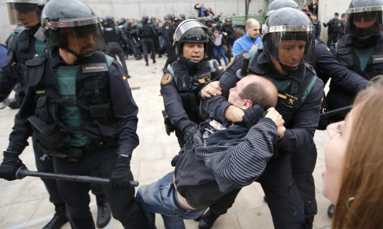 Spanish police drag a man outside a polling station where Catalonia's president was supposed to vote in the region's October 1, 2017 independence referendum.—AFP Spanish police drag a man outside a polling station where Catalonia's president was supposed to vote in the region's October 1, 2017 independence referendum.—AFP