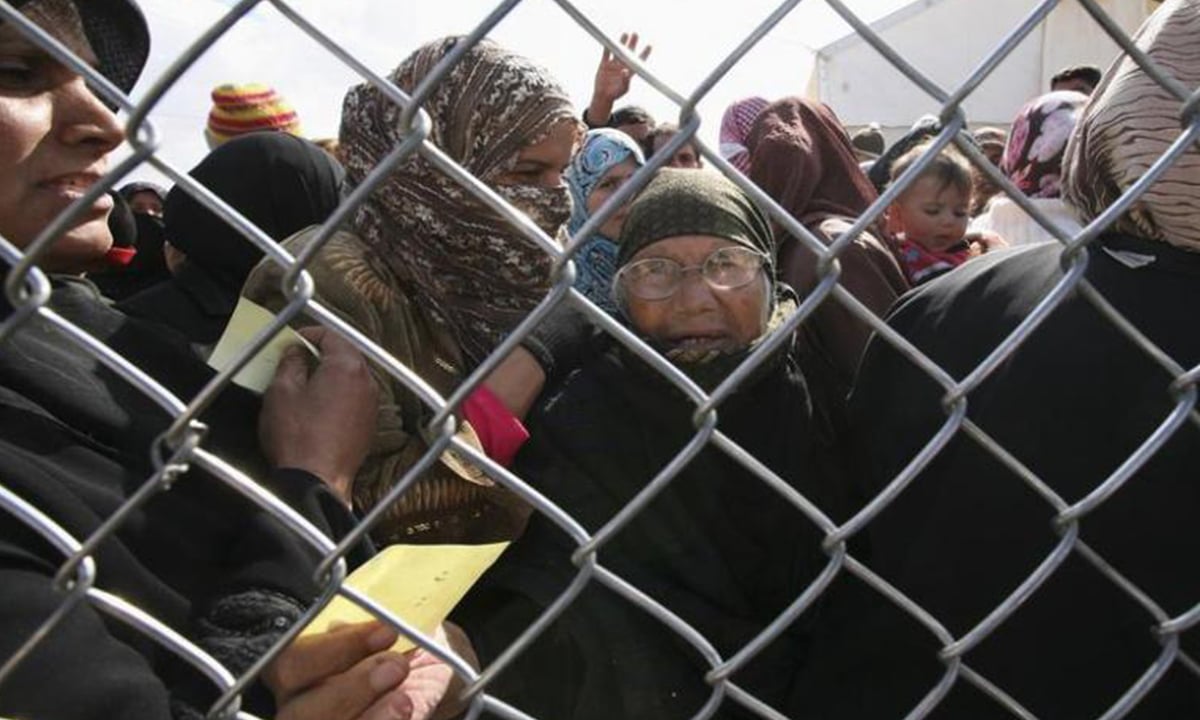 Syrian refugees await registration of their names after arrival at a camp in Jordan, 2013 | Reuters