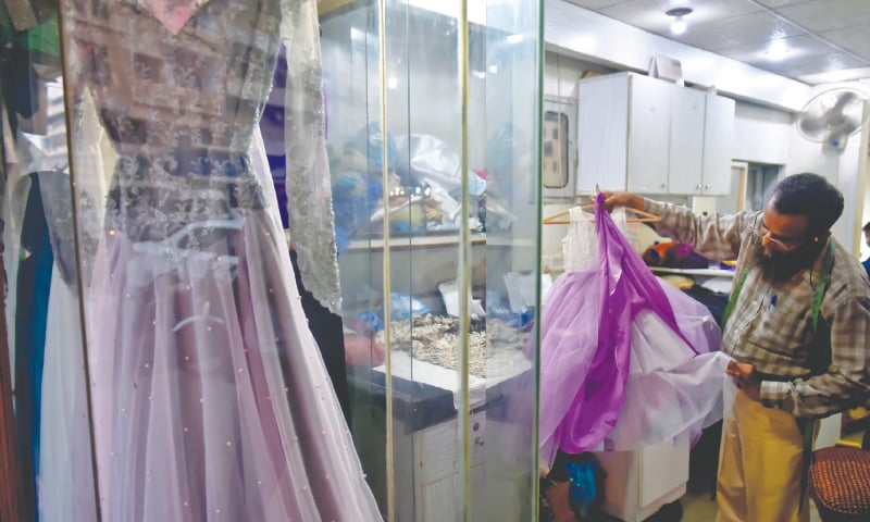 Anwar Qureshi proudly shows a dress stitched by him. / Photos by Fahim Siddiqi / White Star Anwar Qureshi proudly shows a dress stitched by him. / Photos by Fahim Siddiqi / White Star