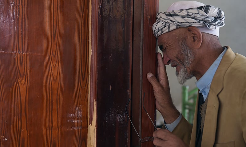 An elderly Afghan resident weeps at Imam Zaman mosque. ─ AFP