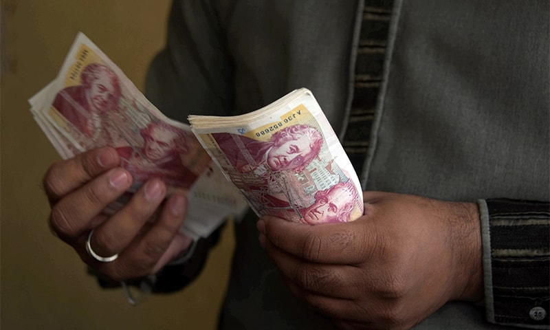 A Kashmiri foreign currency dealer counting British pound notes at a remittance shop in the city of Mirpur, which is known as "Little England." ─ AFP A Kashmiri foreign currency dealer counting British pound notes at a remittance shop in the city of Mirpur, which is known as "Little England." ─ AFP