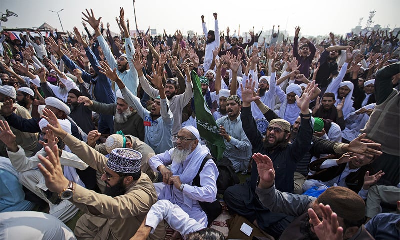 Protesters belonging to religious parties shout slogans during a sit-in in Islamabad on Friday. ─ AP