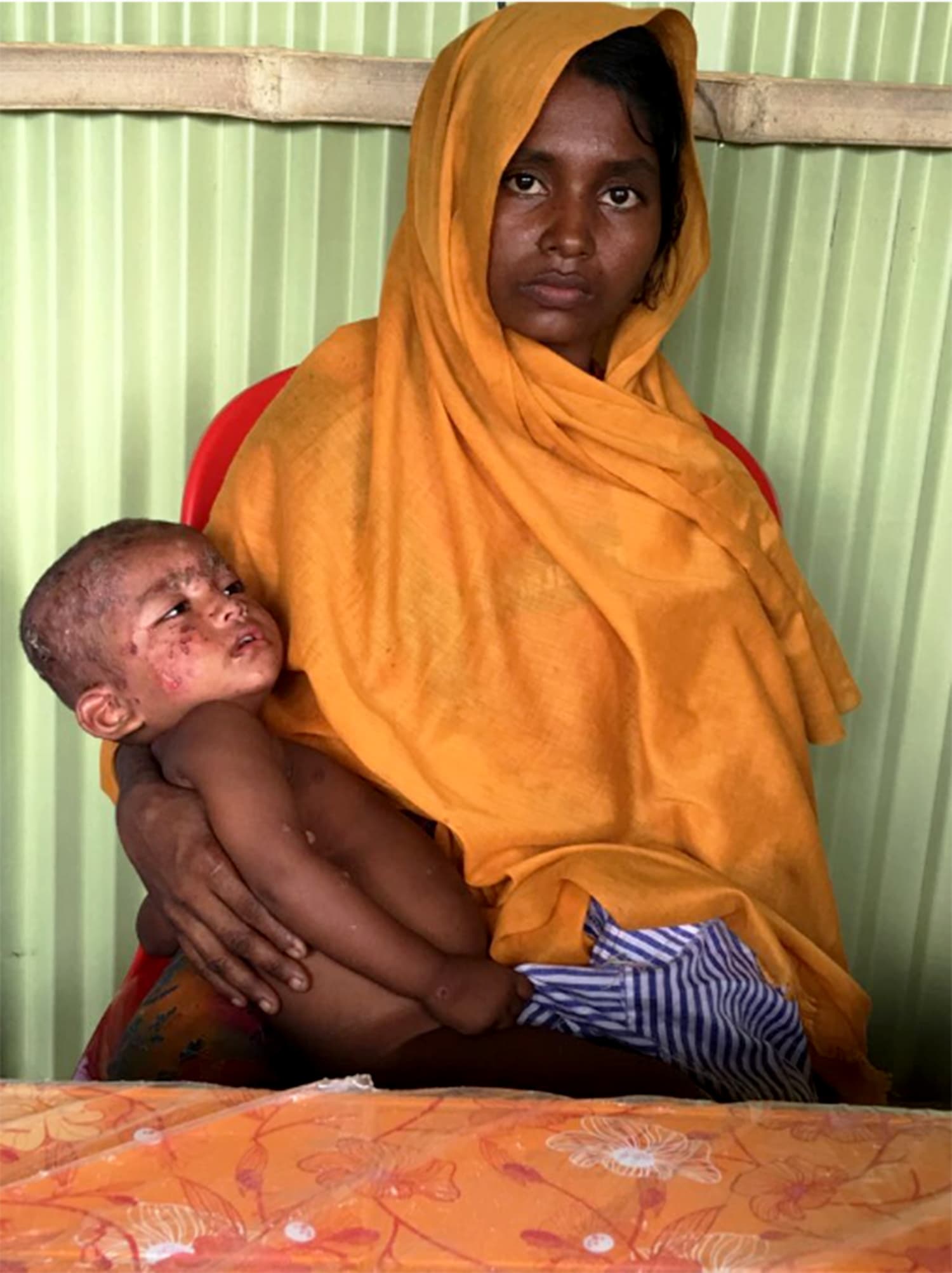 A mother holds her sick child at the clinic. Photocredit: Farida Ahmad