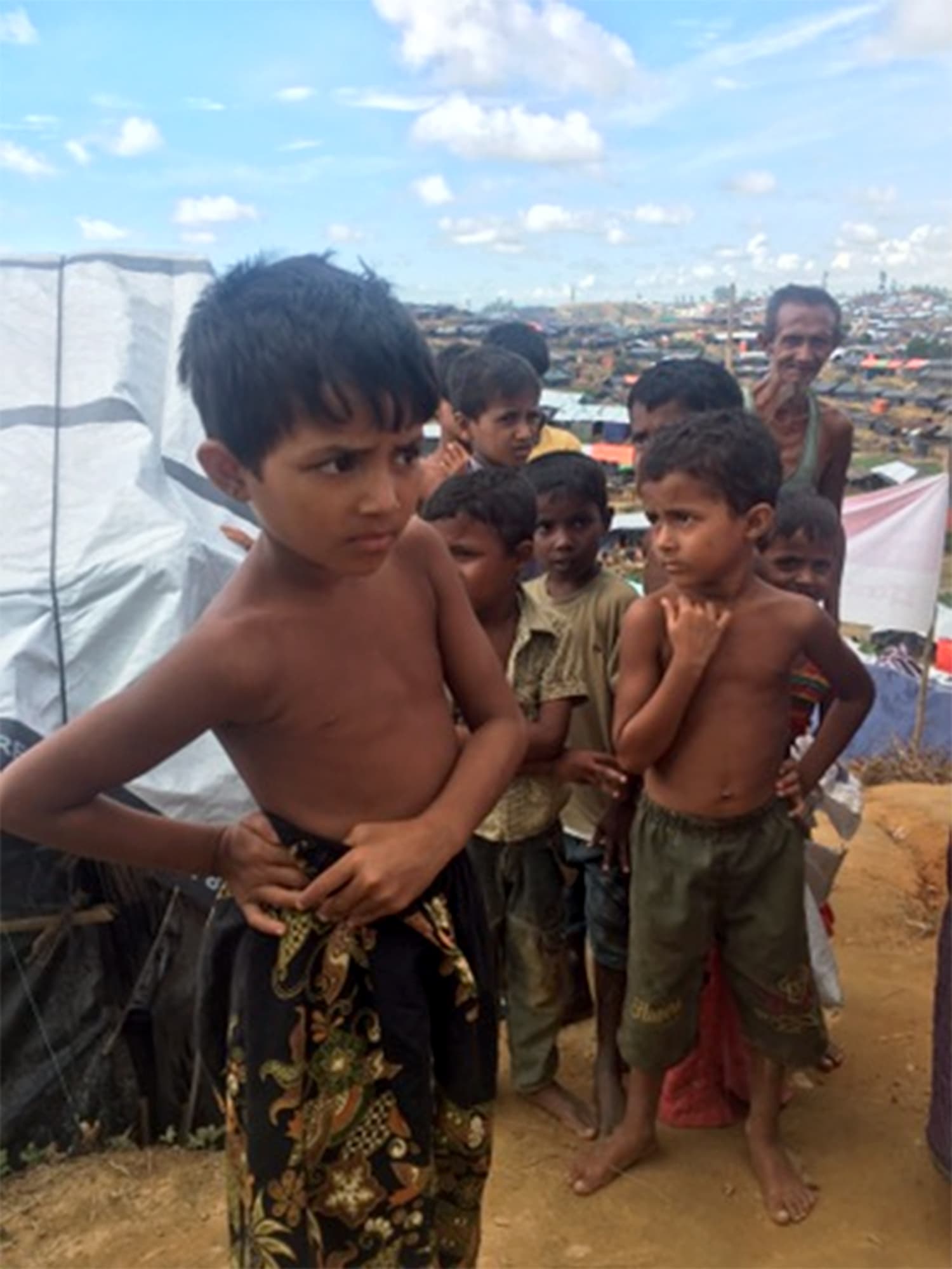 Children stand outside what is now their home.
