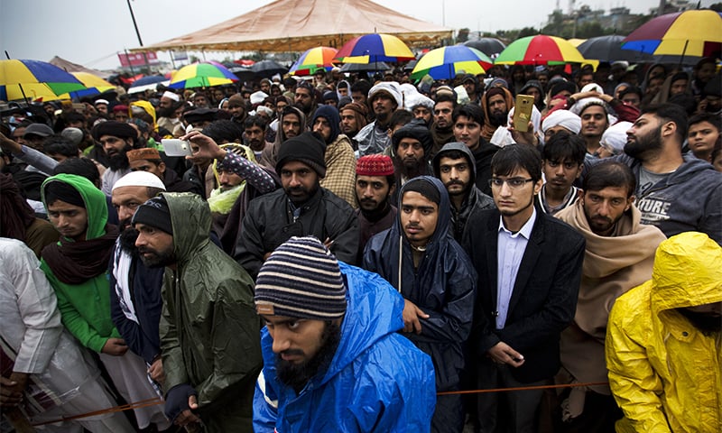 Supporters of religious parties listen to their leaders during a sit-in protest in Islamabad. ─ AP