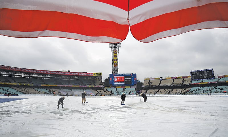 KOLKATA: Groundsmen work to remove water as rain stops play during the first Test between India and Sri Lanka at the Eden Gardens on Friday.&mdash;AFP