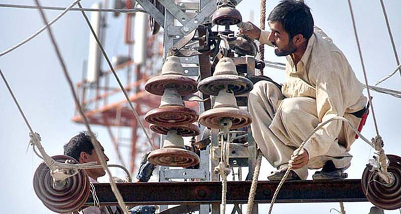 Employees working on a power transmission line in this file photo.