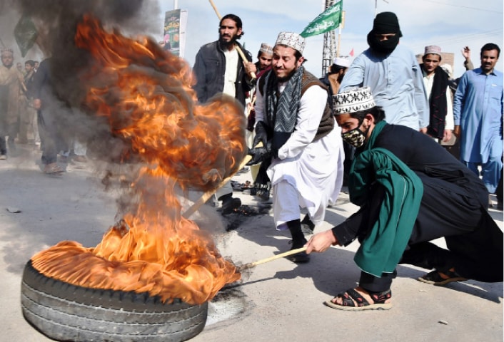 Activists of Tehreek-i-Labbaik Ya Rasool Allah drag burning tyres to block Ring Road, Peshawar, on Saturday. &mdash;White Star