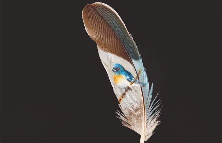Istanbul: Turkish micro artist Hasan Kale displays one of his art works on a feather at his office on Thursday.&mdash;Reuters