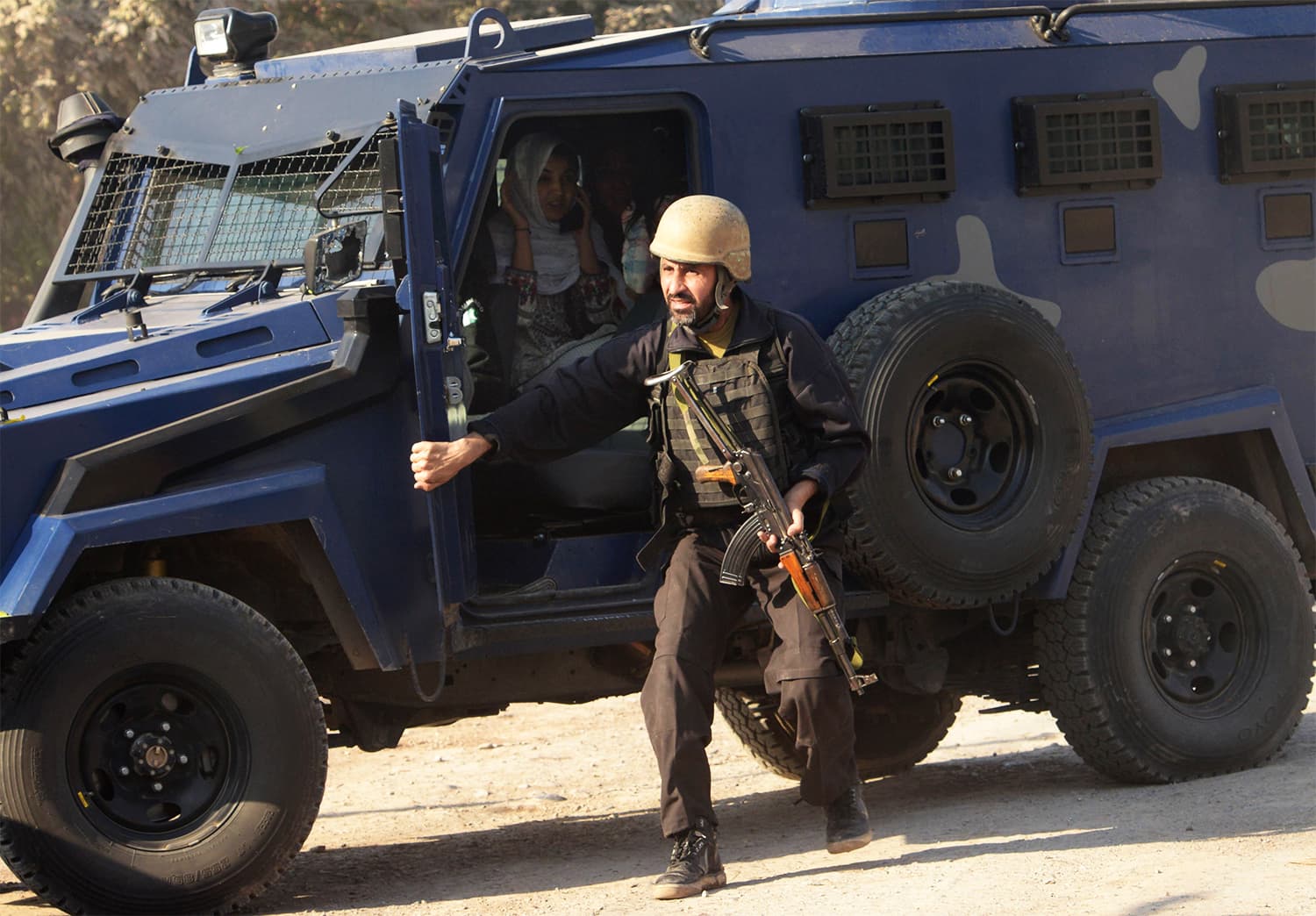 A police commando escorts rescued ATI staff members to safety. ─ AFP