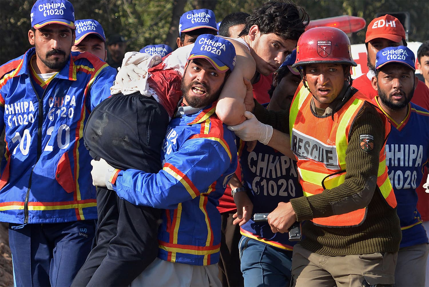 Rescue officials carry an injured student away from the ATI after the attack. ─ AFP