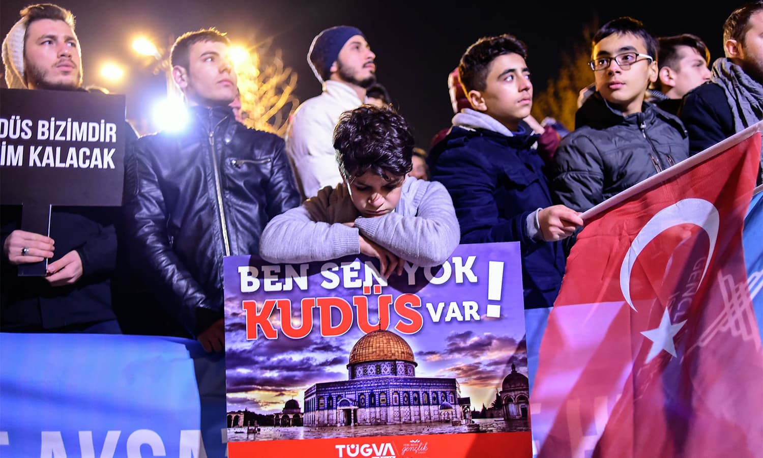 A young boy leans on a sign (C) reading "There is no you or me, there is Jerusalem" during a demonstration at Fatih Mosque in Istanbul.— AFP