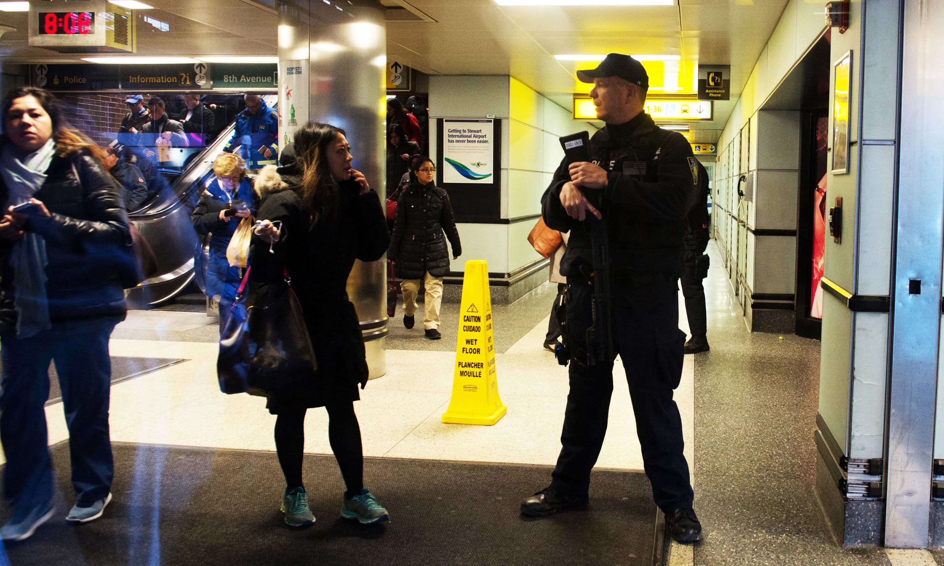 Police watch as people evacuate after a reported explosion at the Port Authority Bus Terminal. &mdash;AFP