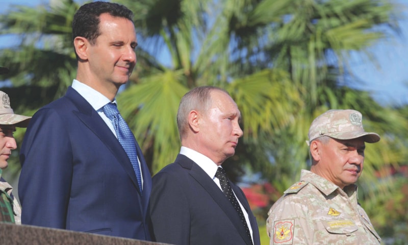 LATAKIA (Syria): Russian President Vladimir Putin (C), Defence Minister Sergei Shoigu (R) and Syrian President Bashar al-Assad visit the Hmeymim air base on Monday.—Reuters