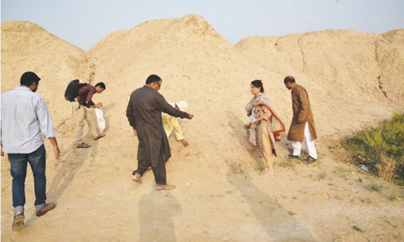 EXPLORERS collect what are believed to be artefacts from a dump of earth along the Indus Highway. The discovery is reported on Friday.&mdash;Dawn