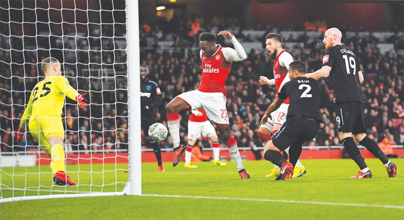 LONDON: Arsenal’s Danny Welbeck taps the ball past West Ham United goalkeeper Joe Hart (L) to score during the League Cup quarter-final
at the Emirates Stadium.—Reuters LONDON: Arsenal’s Danny Welbeck taps the ball past West Ham United goalkeeper Joe Hart (L) to score during the League Cup quarter-final
at the Emirates Stadium.—Reuters