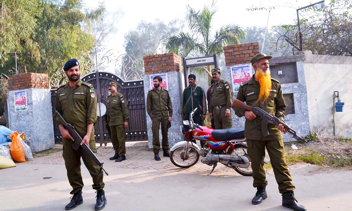 Security personnel high alert on the gate of a Church at College Road, in Sargodha. — APP