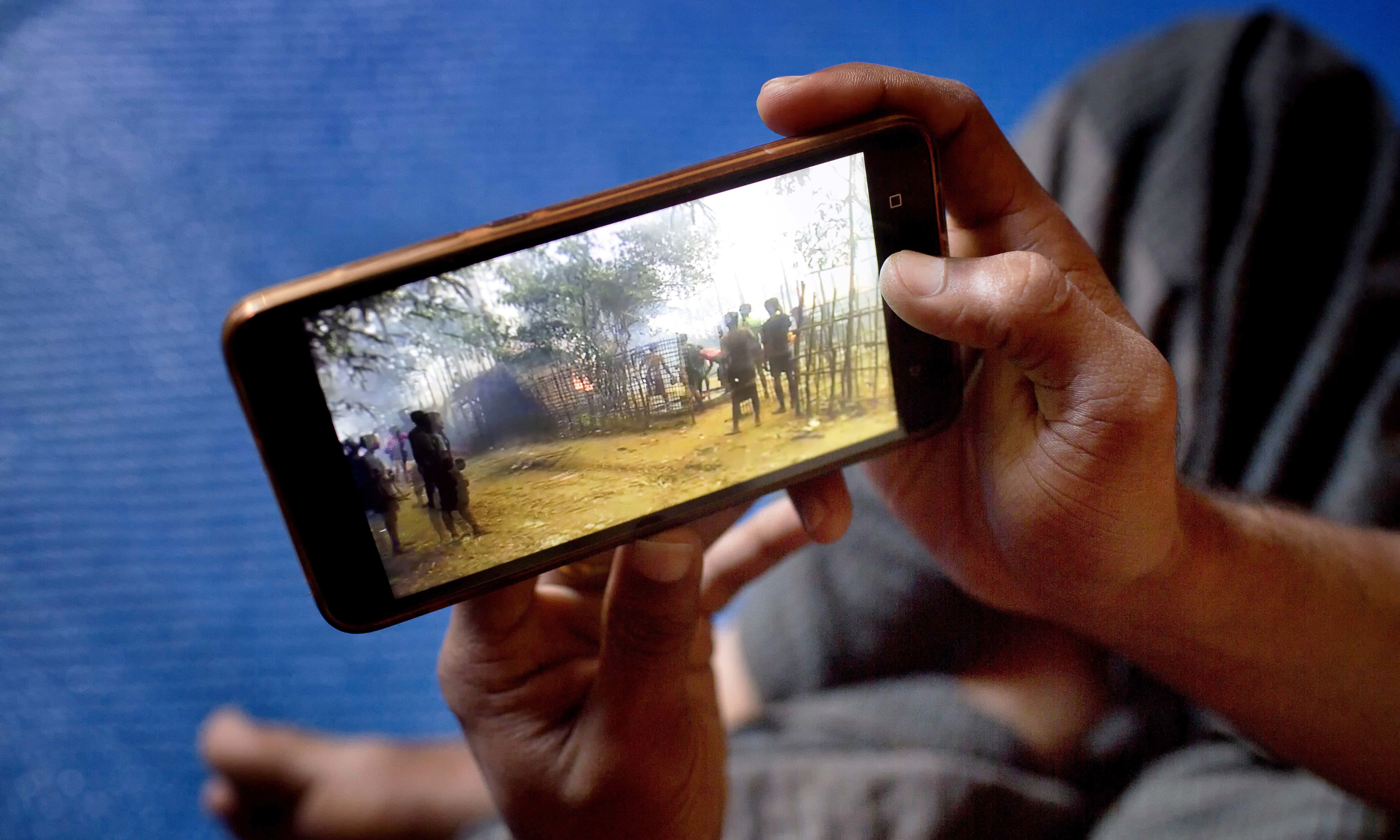 Mujibullah, 22, watches a video which he had shot in Myanmar before crossing over into Bangladesh. —AP