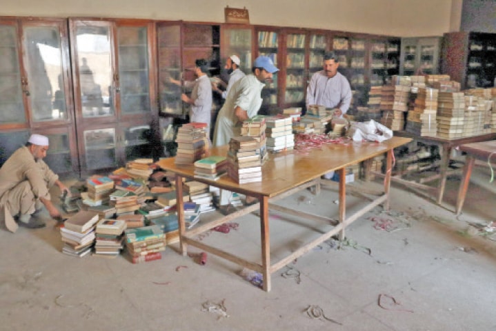 Workers shift books from the library at Gor Khatri prior to its demolition. &mdash; File photos