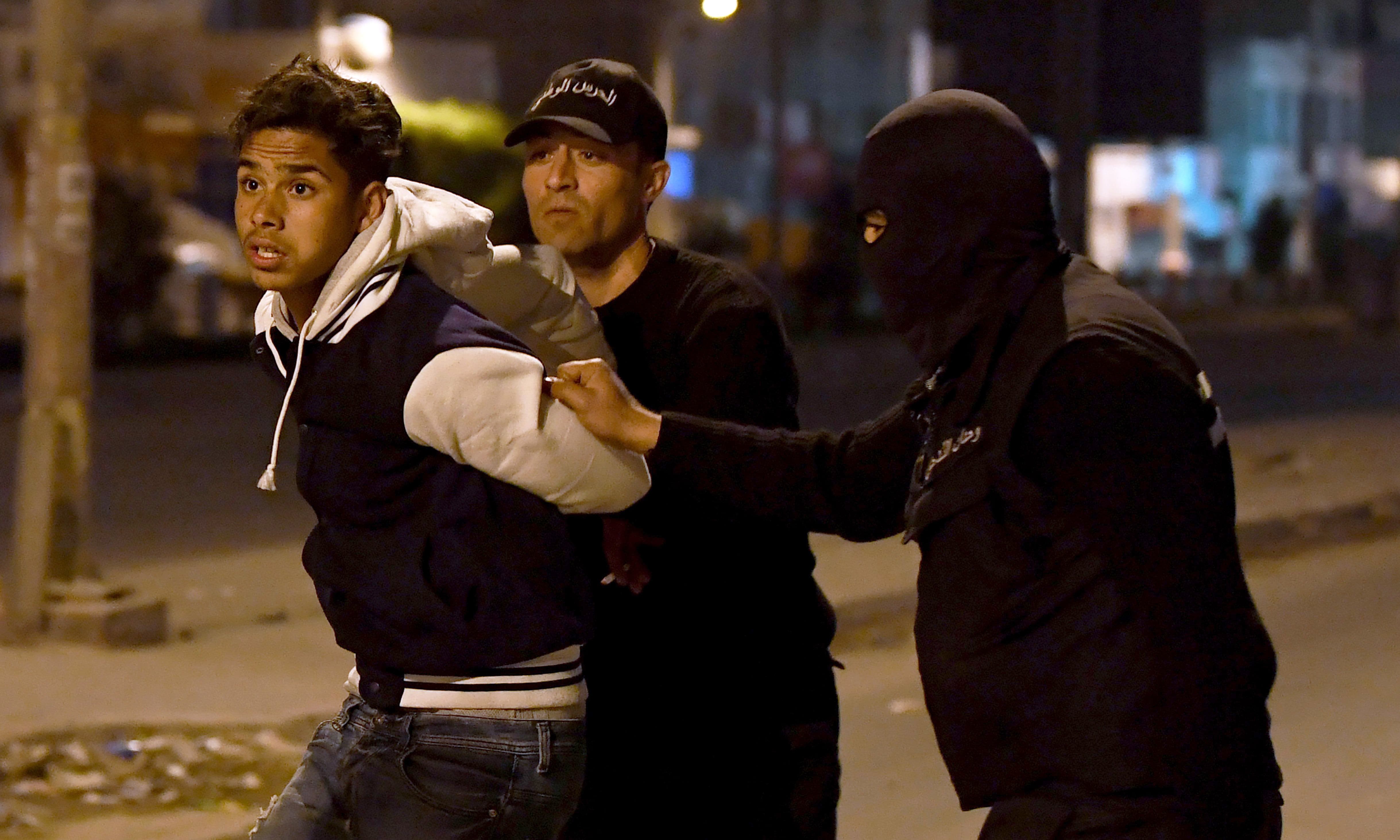 Tunisian security forces detain a protester in the Ettadhamen on the outskirts of Tunis late on January 10, 2018, after price hikes ignited protests in the North African country. &mdash;AFP