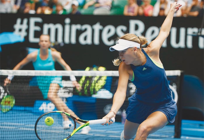 MELBOURNE: Denmark’s Caroline Wozniacki hits a return to Magdalena Rybarikova of Slovakia during their Australian Open match at the Rod Laver Arena on Sunday.—Reuters