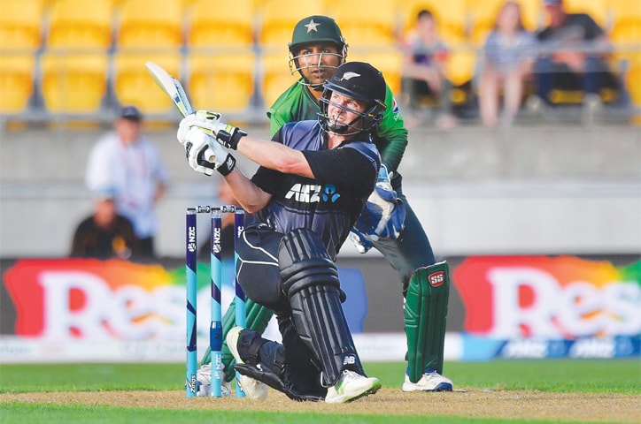 WELLINGTON: New Zealand opener Colin Munro hits out as Pakistan captain Sarfraz Ahmed looks on during the first T20 International at Westpac Stadium on Monday.&mdash;AFP