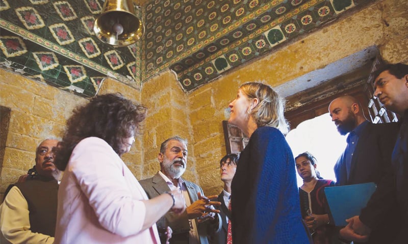 UNITED States Consul General Grace Shelton looks at the restored ceiling of Varun Dev Mandir at Manora on Thursday as Dr Kaleemullah Lashari and 
Dr Asma Ibrahim brief her.—PPI