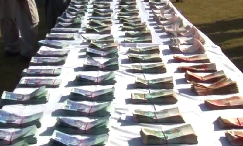 Fake currency seized during the raid in Peshawar is displayed by police.&mdash; DawnNews