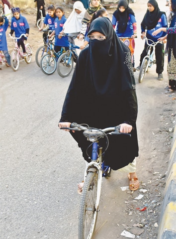 GIRLS from the Lyari Girls’ Cafe learning to ride on rented bicycles in front of the Naval flats. —Fahim Siddiqi / White Star