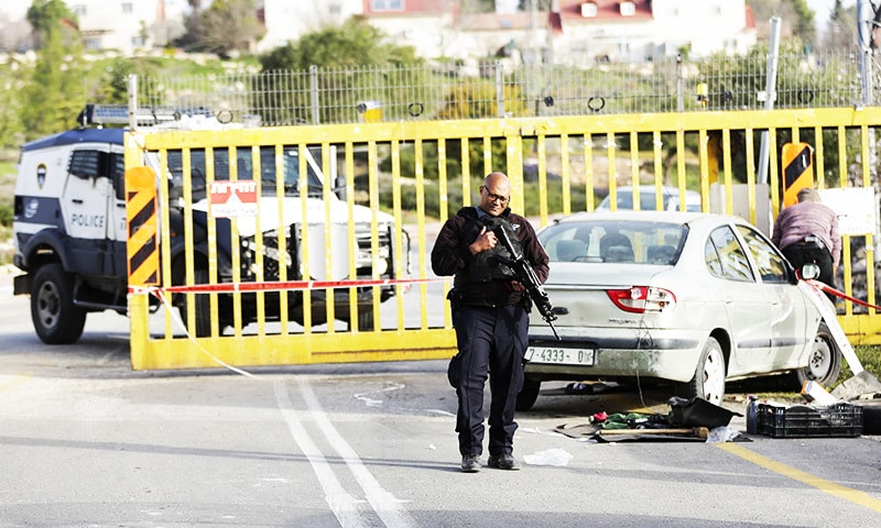Israeli security stands around a car involved in an attack at the entrance of Carmei Tzur settlement in the West Bank.—AP Israeli security stands around a car involved in an attack at the entrance of Carmei Tzur settlement in the West Bank.—AP