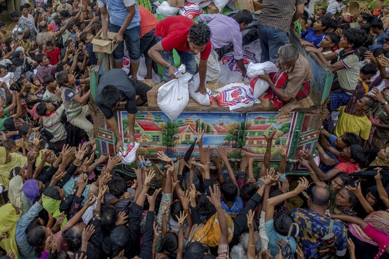 In this Sept 18, 2017, file photo, Rohingya Muslims, who crossed over from Myanmar into Bangladesh, reach out for food distributed by aid agencies near the Balukhali refugee camp in Cox’s Bazar. ─ AP