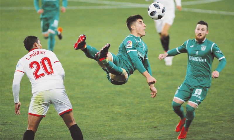 SEVILLE: Leganes’ Unai Bustinza (C) heads the ball as Sevilla’s Luis Muriel (L) looks on during the Copa del Rey semi-final at the Ramon Sanchez Pizjuan.—Reuters SEVILLE: Leganes’ Unai Bustinza (C) heads the ball as Sevilla’s Luis Muriel (L) looks on during the Copa del Rey semi-final at the Ramon Sanchez Pizjuan.—Reuters