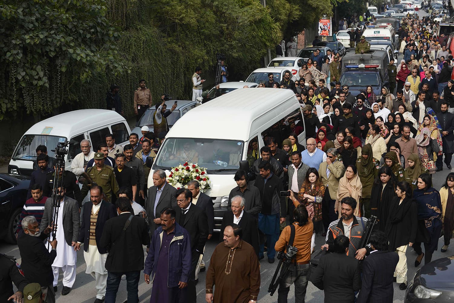 Mourners march alongside a vehicle carrying the coffin of lawyer and rights advocate Asma Jahangir during her funeral in Lahore. — AFP