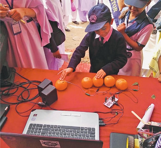 A young student is all smiles as he interacts with a science model at a stall.—Dawn