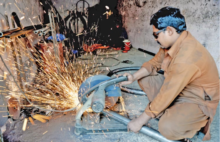 A blacksmith cuts iron pipes.