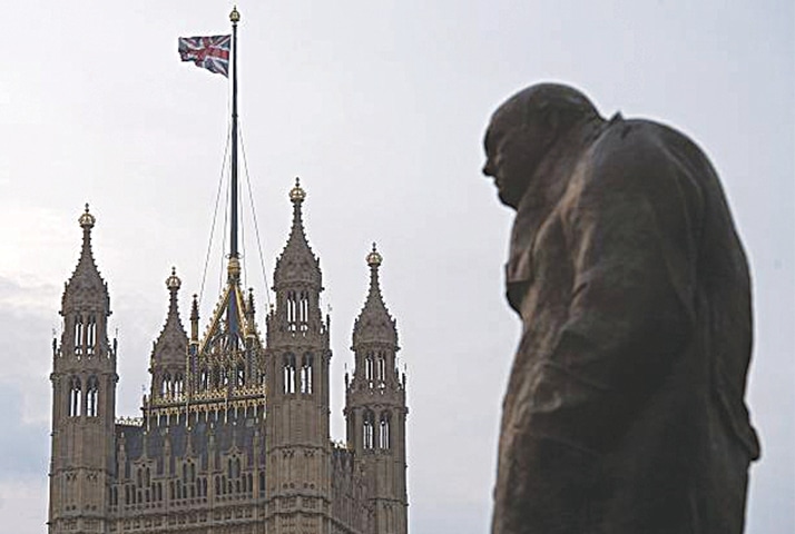 A STATUE of former British prime minister Winston Churchill stands near the Victoria Tower of the Houses of Parliament, as a British Union flag flies from a pole atop the tower, in London.—AFP