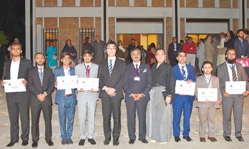 Pakistani students pose for a photograph with Charge d&rsquo;Affaires Takashi Harada after their pre-departure orientation.