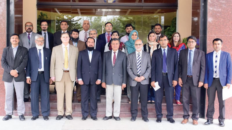 Officials of Bahria University and PIEAS pose after MoU signing ceremony. — Dawn